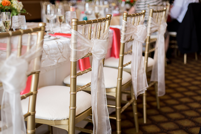 Ashley & Brad - The Club at Key Center Wedding | Orchard Photography | Real Ohio Wedding as seen on Todaysbride.com | Cleveland wedding, wedding photography, gold chiavari chairs, chair sashes, gold and coral wedding decor