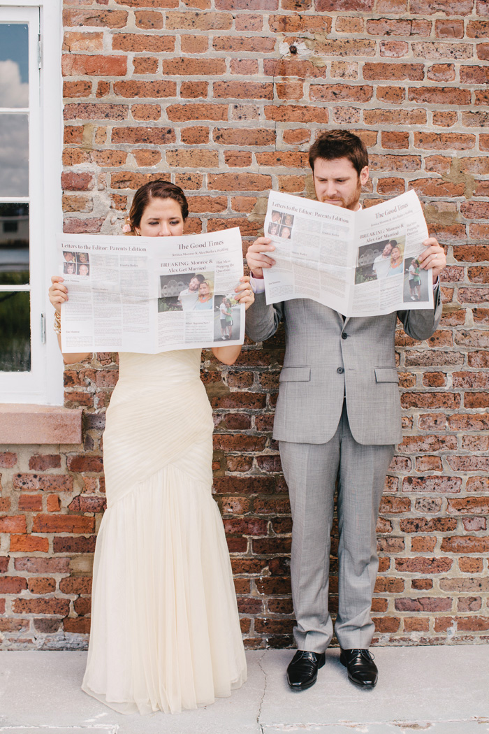 Bride and groom holding newspaper program | Riverland Photography | As seen on TodaysBride.com