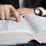 bigstock Man Looking In The Large Dicti 72580765