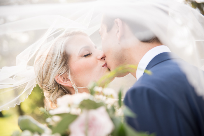 Bride and groom kissing under a veil | Sabrina Hall Photography | As seen on TodaysBride.com