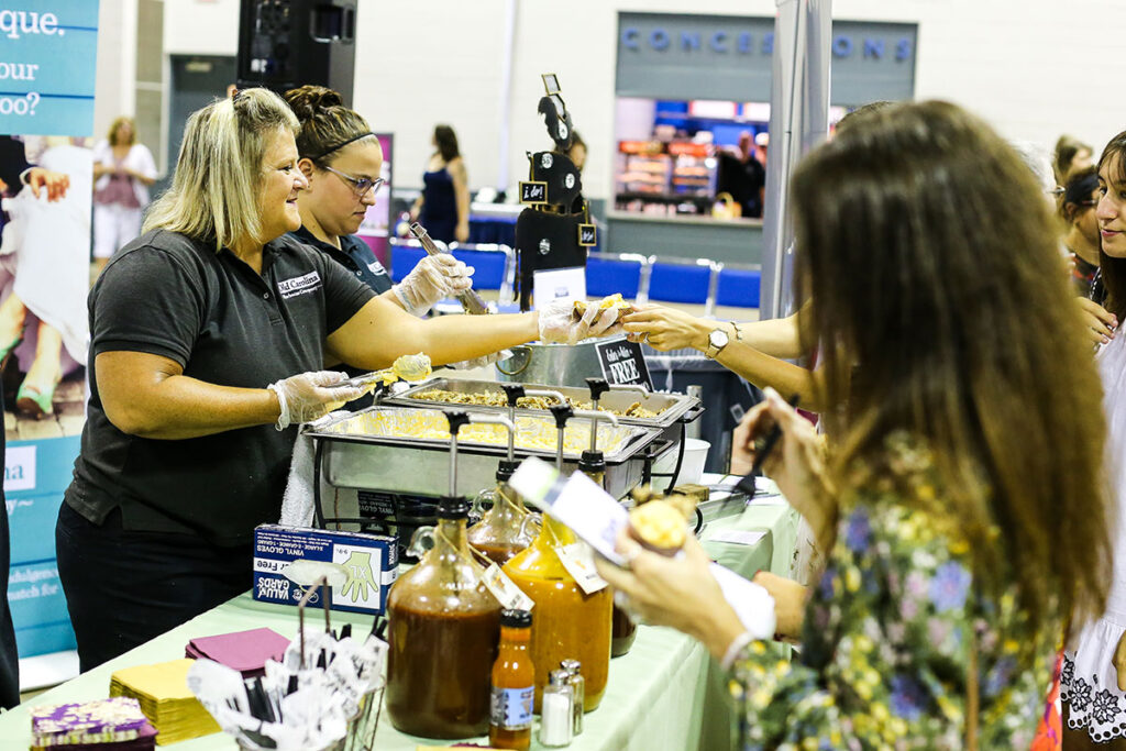OldCarolinaSamples 1200x800 - 15 Wedding Expo Booth Ideas That Attract More Couples Old Carolina BBQ handing out catering samples at bridal show