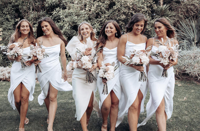 Bride and bridesmaids in white dresses with bouquets