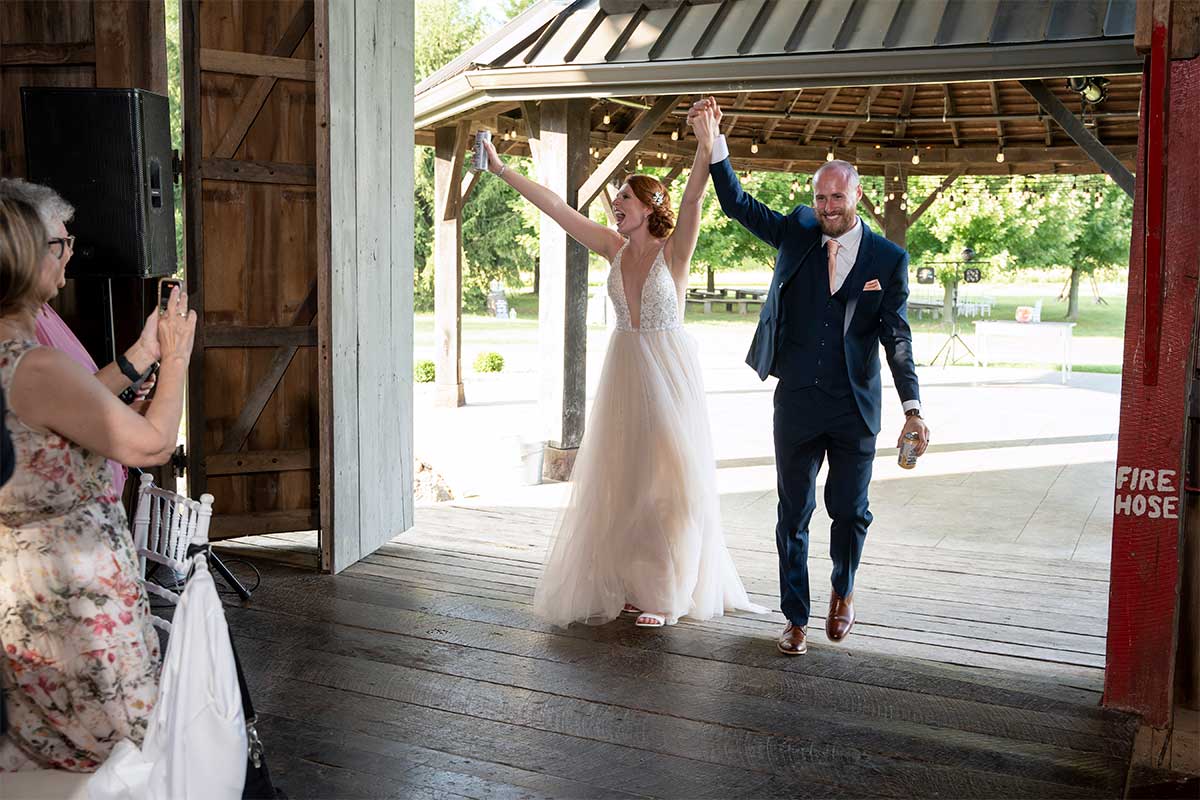 couple entering barn wedding reception