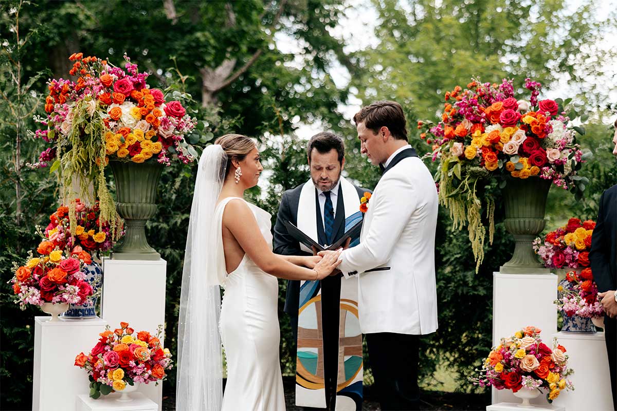 bride and groom taking vows floral colorful wedding